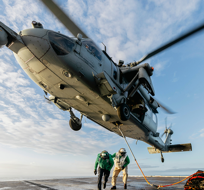 A large helicopter dropping off two people